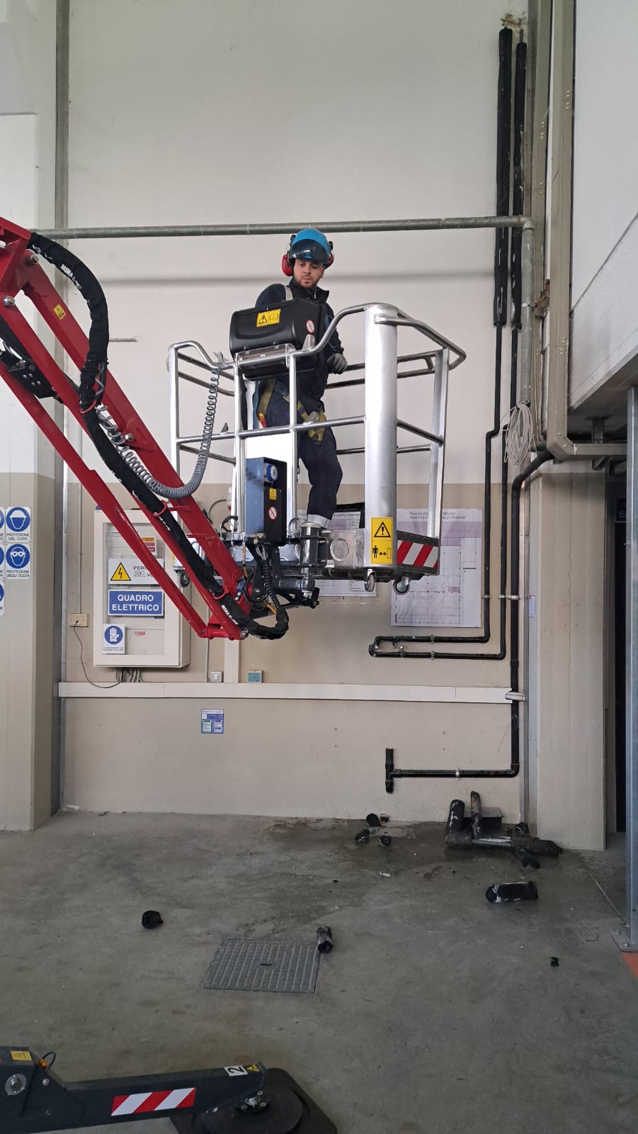 Tecnico Melillo Technology su piattaforma aerea durante lavori impiantistici in un capannone industriale